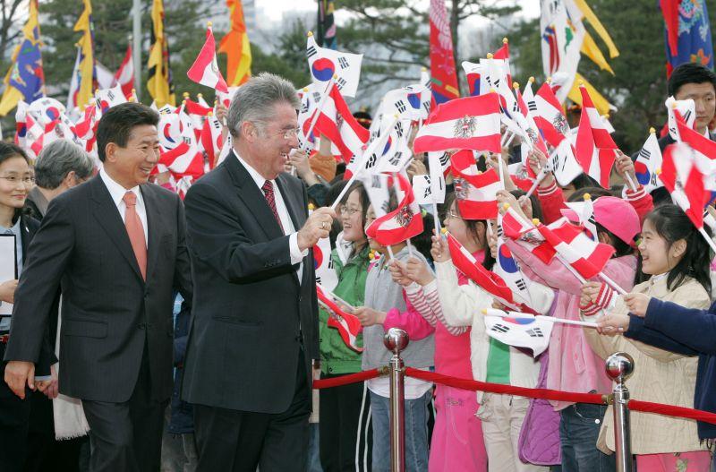 [오스트리아 피셔 대통령 공식환영식에서 환영하는 어린이들에게 국기를 흔들며 인사하는 양국 정상]
