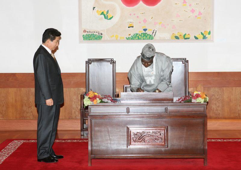 [방명록에 서명하는 올루세군 오바산조 나이지리아 대통령과 임석한 노무현 대통령]