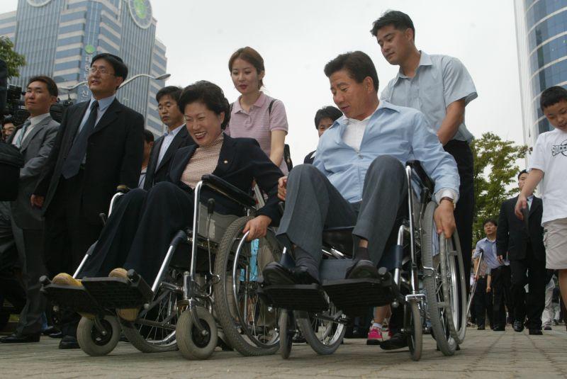 [휠체어를 타고 이동하는 노무현 민주당 대통령후보와 김화중 의원]