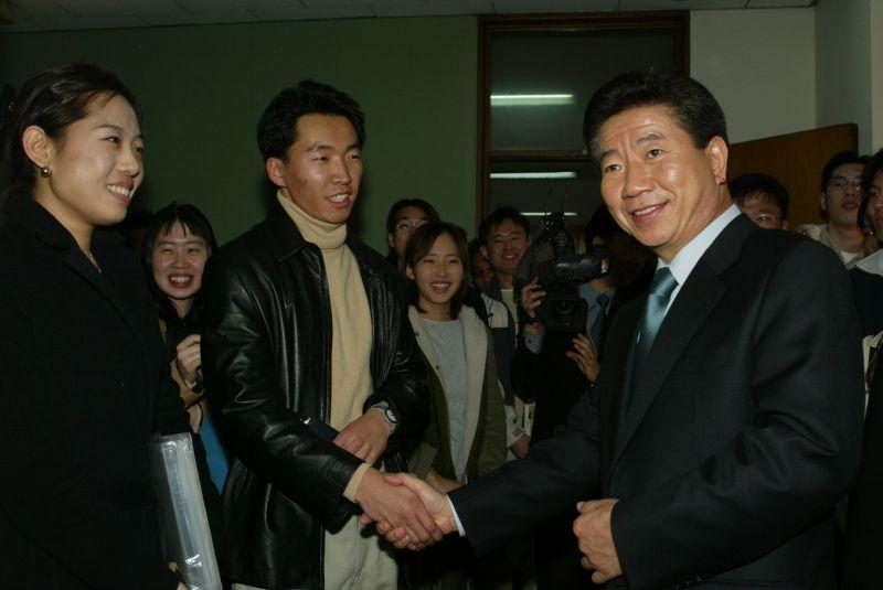 [2002 서울 채용박람회에 참석한 대학생들과 악수를 나누는 노무현 민주당 대통령후보]