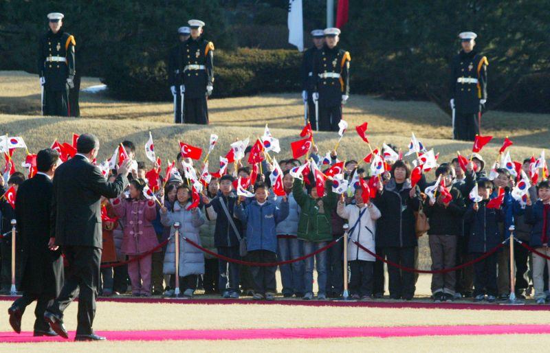 [터키 총리의 공식환영식에서 환영나온 어린이들에게 손을 들어 인사하는 양국 정상]