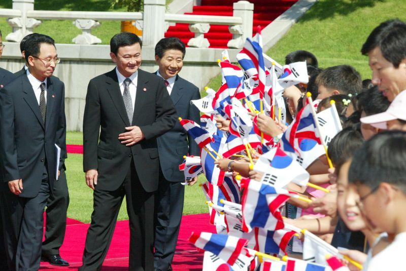 [공식환영식에서 양국 국기를 흔들며 환영하는 어린이들에게 인사하는 탁신 치나왓 총리와 노무현 대통령]