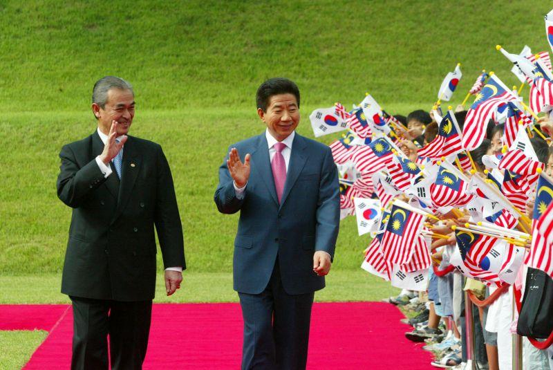 [청와대에서 열린 공식환영식에서 양국 국기를 흔들며 환영하는 어린이들에게 손을 들어 인사하는 두정상]