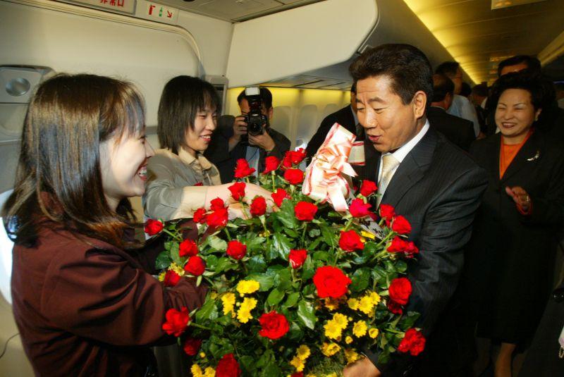 [해외순방길에 58번째 생일을 맞은 노무현 대통령에게 꽃다발을 전달하는 기자단]