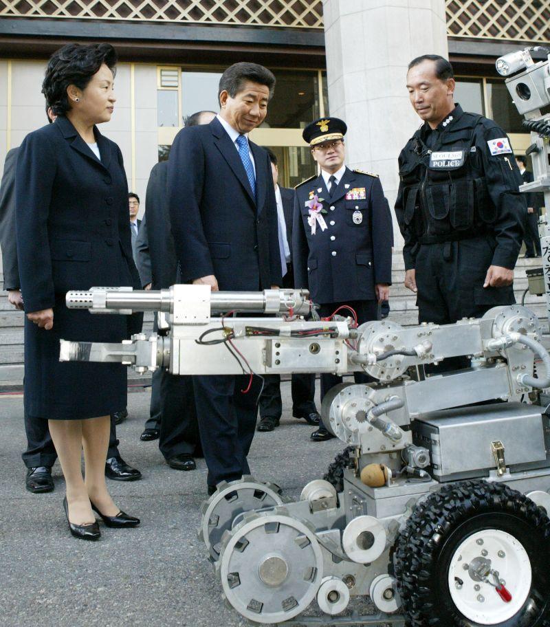 [제59주년 경찰의 날 기념식에서 폭발물 탐지로봇을 살펴보는 노무현 대통령 내외]